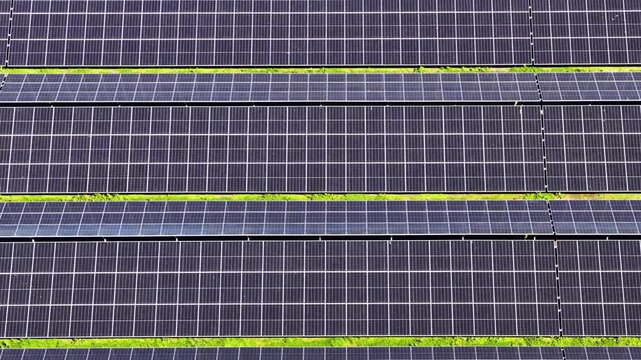 Aerial drone view of a massive solar panel field. Sustainable green energy farm and photovoltaic power station for renewable electricity production and environmental conservation.