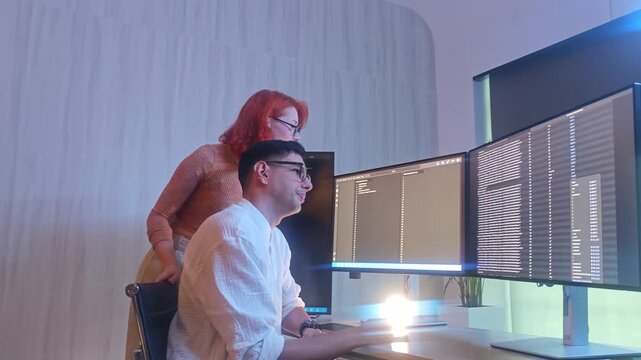 Programmers working at night analyzing code on monitors in a modern office. Software developers collaborating on debugging cybersecurity and data programming projects. Ai coding Software technician.