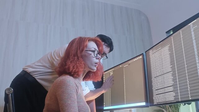 Programmers working at night analyzing code on monitors in a modern office. Software developers collaborating on debugging cybersecurity and data programming projects. Ai coding Software technician.