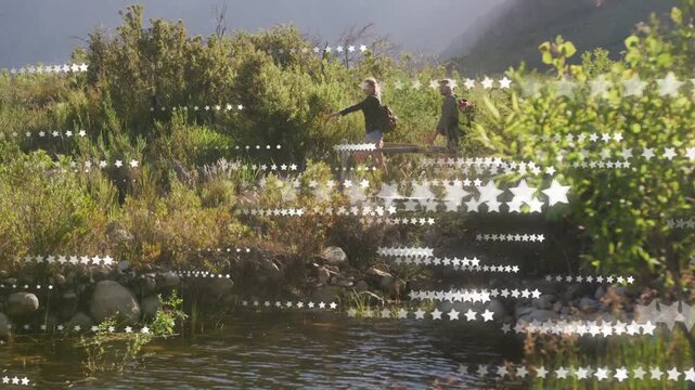 Female pointing, male following, hiking pond edge past rocks, tech star overlay obscuring pair