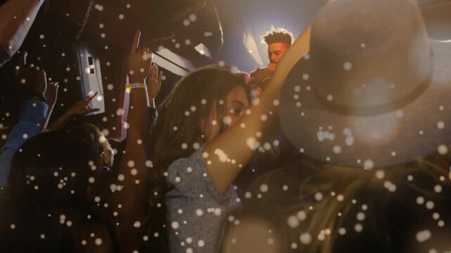 Singer starting song into mic under stage lights, front woman raising right arm, confetti floating