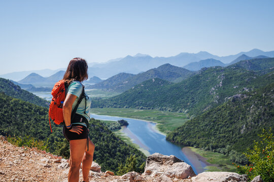 Woman tourist with backpack hiking at Crnojevica river in natural parkland Lake Skadar. Active summer vacation in Montenegro