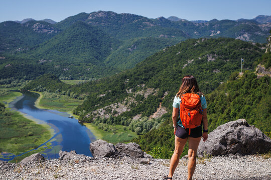Woman tourist with backpack hiking at Crnojevica river in natural parkland Lake Skadar. Active summer vacation in Montenegro