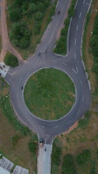 Roundabout Amid Trees. Aerial Perspective Of Lush Green Circular Junction. Elevated Perspective Highlighting Dense Forest Surrounding Circular Traffic Circle With Natural Buffer Zones