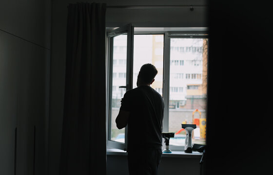 Man washing and cleaning window at home. Housework and housekeeping, home hygiene