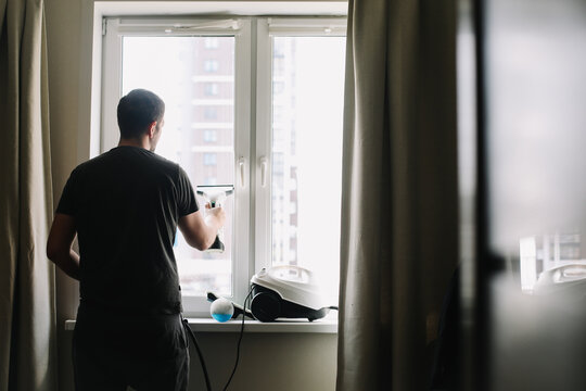 Man washing and cleaning window at home. Housework and housekeeping, home hygiene