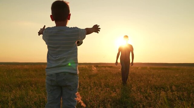 Son dad having fun playing ball on green grass. Family kid sport. Child son play football with father on lawn. Family team, sports games. Boy child goalkeeper dad kicks ball, goal. Active happy family