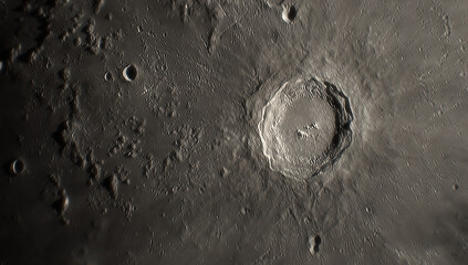 A photo of the lunar surface through an amateur telescope. The lunar surface is pockmarked with craters. © Sergei