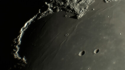 A photo of the lunar surface through an amateur telescope. The lunar surface is pockmarked with craters. © Sergei