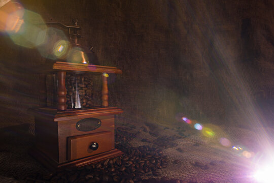 Coffee beans poured into a hand coffee grinder.