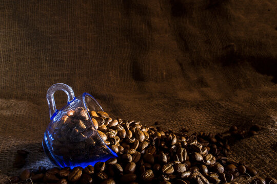 Coffee beans poured into a coffee cup.