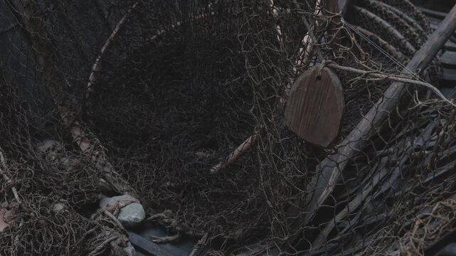 A pile of fishing nets and a wooden sign, great for outdoor scenes or rustic settings
