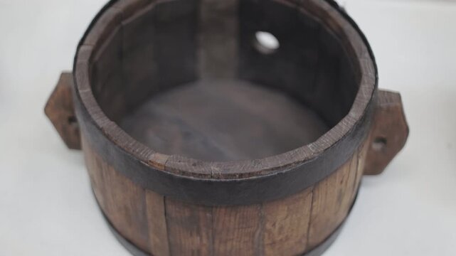 A simple wooden bucket placed on a table with a rustic atmosphere