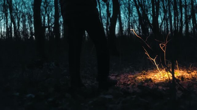 Close Up Feet Of One Man Walking In Dark Forest With Flashlight lifestyle