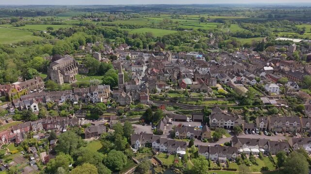 Aerial drone footage of Malmesbury, a historic market town in Wiltshire, England, nestled within the Cotswolds, Scenic view featuring traditional architecture, the River Avon