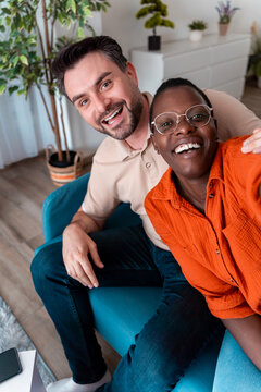 Smiling friends sitting together in a cozy living room during the daytime