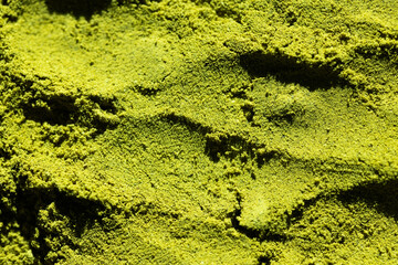 Fototapeta premium textured surface of green matcha powder natural background perfect for health, food, or branding visuals