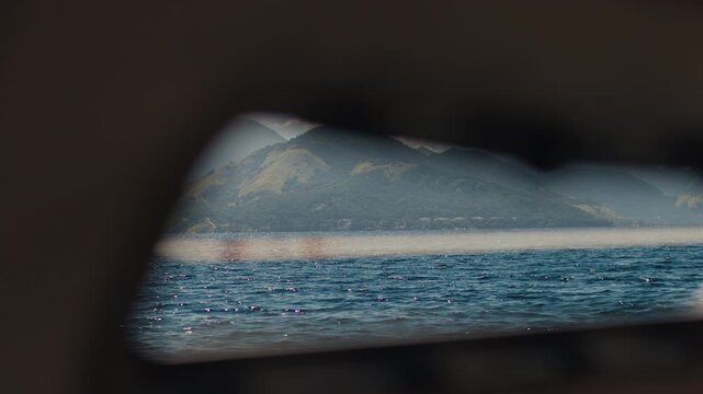 Island of Ilha Grande in Brazil as seen through the illuminator of the moving sailing boat
