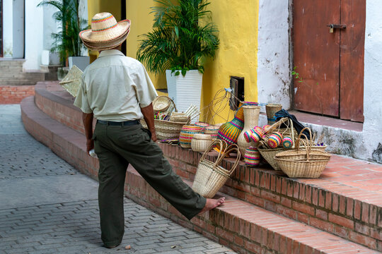 Colombia, a street vendor in Santa Cruz de Mompox offers handmade baskets for sale.