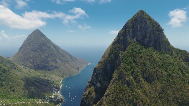 Aerial view of the iconic Piton mountains in Saint Lucia with lush green tropical vegetation covering volcanic peaks.