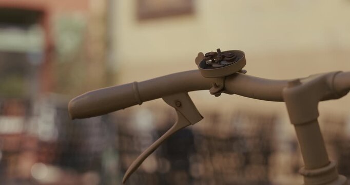 A close-up view shows a bicycle handlebar with a mounted bell.