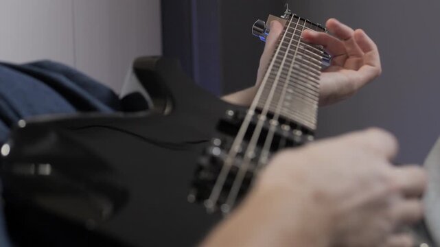 play electric guitar close up fingers slide over strings of electric guitar