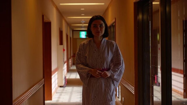 Woman in kimono walking in hallway of traditional japanese house