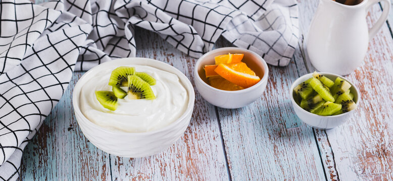 Thick fermented skim milk product with probiotics and kiwi in a bowl on the table web banner