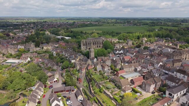 Aerial drone footage of Malmesbury, a historic market town in Wiltshire, England, nestled within the Cotswolds, Scenic view featuring traditional architecture, the River Avon