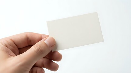 Obraz premium Hand holding blank white business card mockup on clean background for branding and corporate identity design projects.