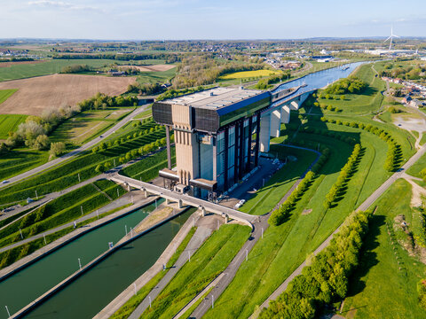 Top down drone view of canal boat lift showing geometric layout of concrete towers and steel structure, symmetrical engineering design of hydraulic waterway lifting mechanism for green freight