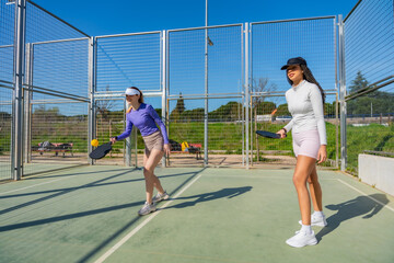 Obraz premium Women playing pickleball on an outdoor court