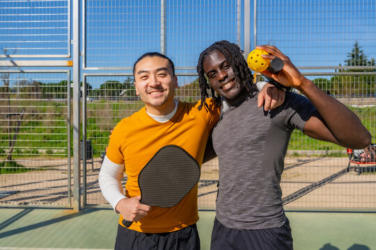 Diverse friends enjoying pickleball game on court