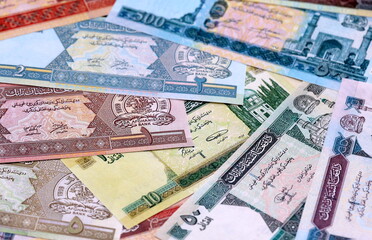 Obraz premium Afghan afghani money bills pile on table. Afghanistan banknotes of AFN currency close up.