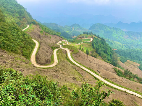 Ha Giang, Vietnam - March 08, 2020: Towering Green Hills Framing a Winding Scenic Road Along the Famous Ha Giang Loop