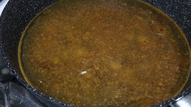 A pot of hot soup sitting on the stovetop