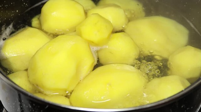A pot filled with potatoes sits on top of a stove, ready to be cooked