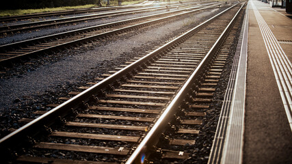 Railway infrastructure with train rail track and railway station platform forming industrial railway background and rail transport logistics travel concept.