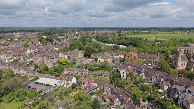 Aerial drone footage of Malmesbury, a historic market town in Wiltshire, England, nestled within the Cotswolds, Scenic view featuring traditional architecture, the River Avon
