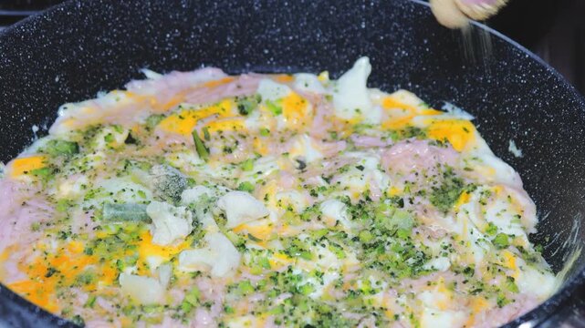 A tasty omelet filled with steaming hot broccoli and melted cheese, cooked to perfection in a sizzling pan
