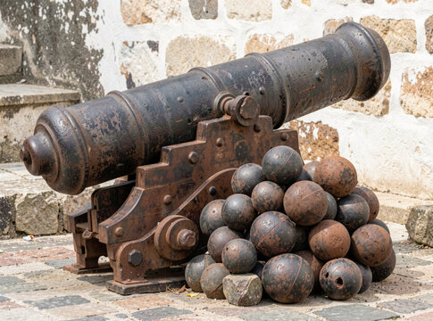 A cannon sits atop a stack of colorful balls, ready for action
