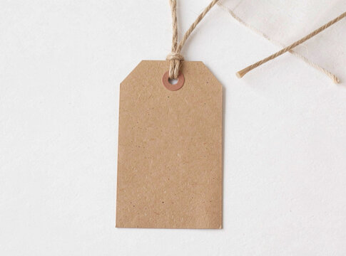 A single brown tag hangs from a string on a white background, ready to be used for identification or decoration