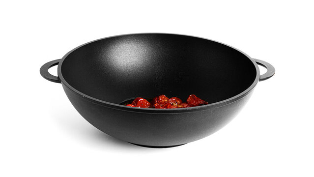Stewed cherry tomatoes with garlic in a wok pan isolated on a white background. Preparation of bucatini pasta.