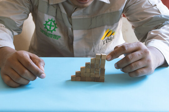 Industrial worker hands arranging wooden blocks into staircase for business growth concept, 