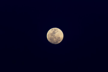 Obraz premium Full moon in the night sky with clouds and sunbeams.