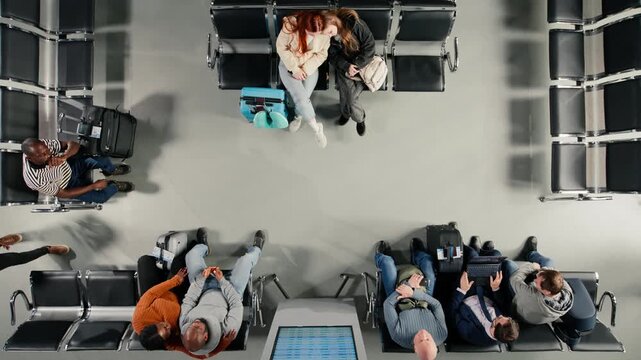 Sisters sleeping in airport lounge and people checking flight schedule screen. Family members napping in airplane departure terminal and passengers looking at flight timetable on display