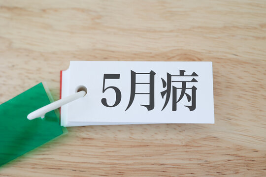 5月病のイメージ。木目背景にカード。新環境への不適応。GW明け。鬱な気分