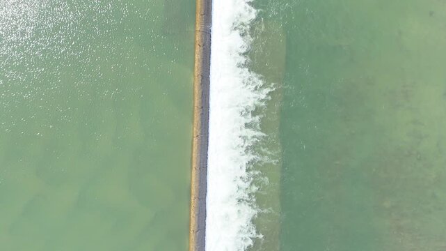 Drone footage shows river water splitting over a weir