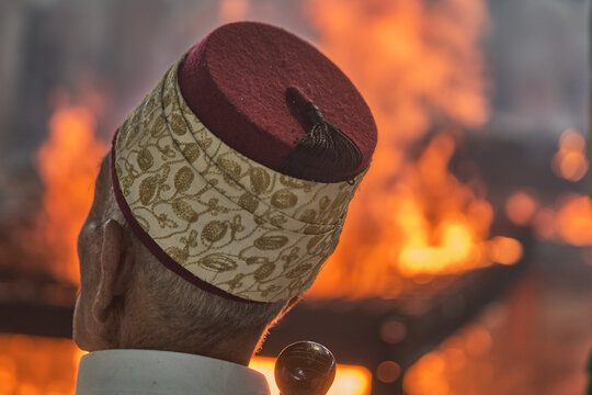 Hand holding traditional staff near fire during Samaritan Passover ritual