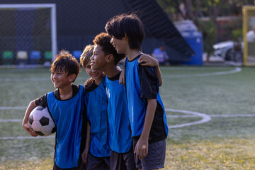 Group of boys and girls enjoy to practice to play soccer together outdoor in football field with day light and they look happy to exercise to get good health, sport concept. © unikyluckk